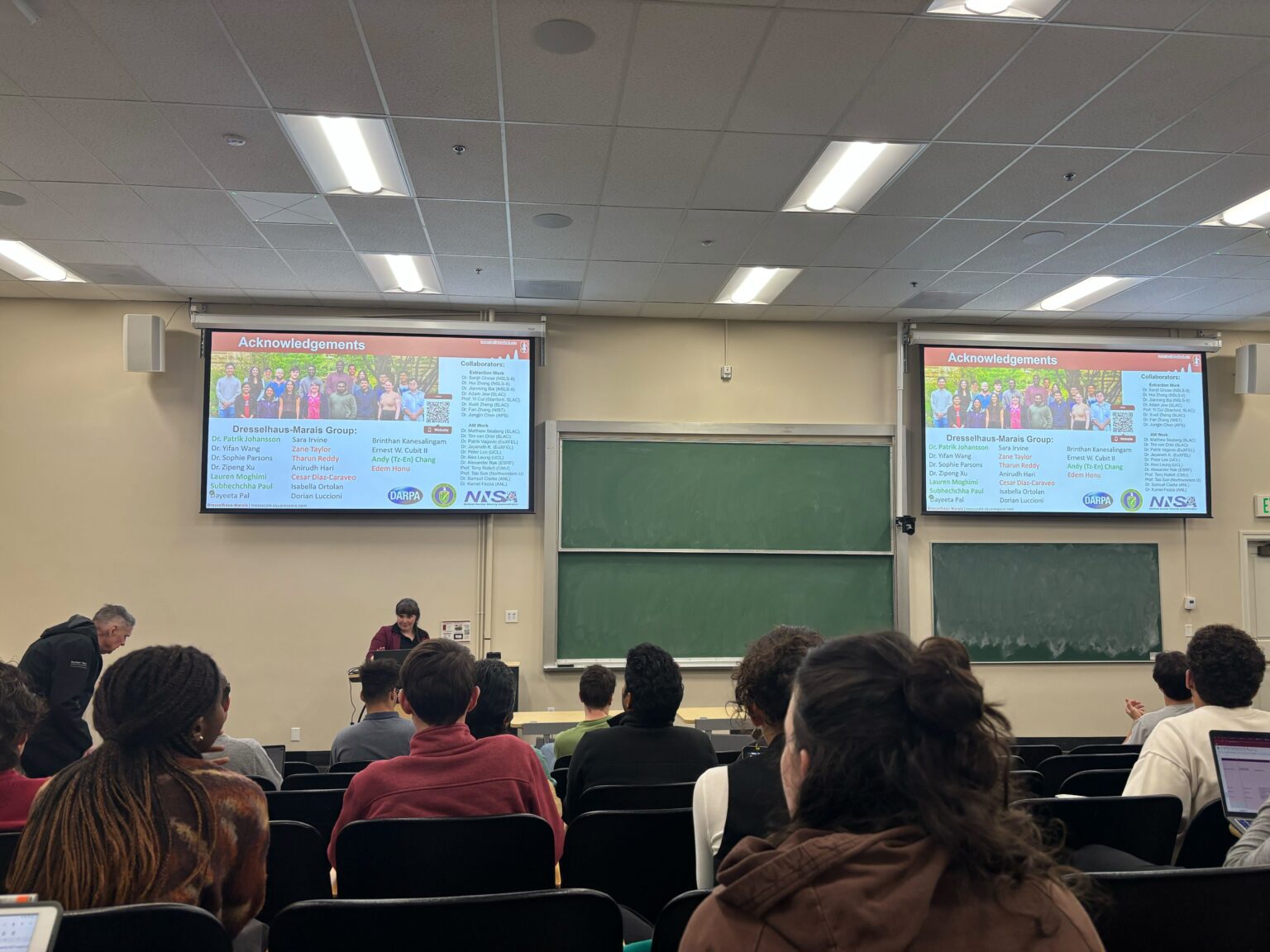 People watch the Stanford Energy Seminar in a classroom-style room.