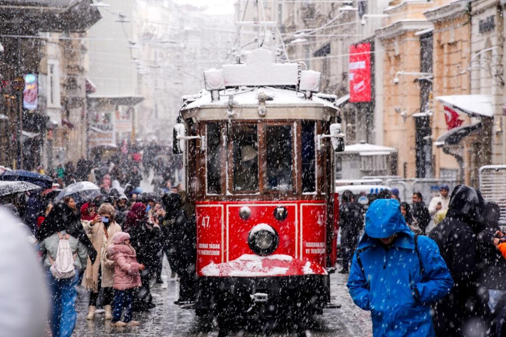 Snowfall continues to affect parts of Istanbul, Türkiye, as a tram travels through the snow-covered street, on the first day of the new year on Jan 1, 2026. (AA Photo)