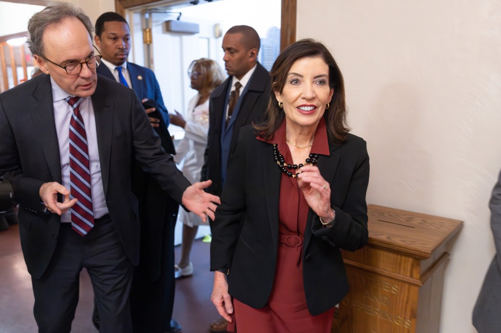 New York Governor Kathy Hochul smiling while leaving Abyssinian Baptist Church with her husband, Bill Hochul.