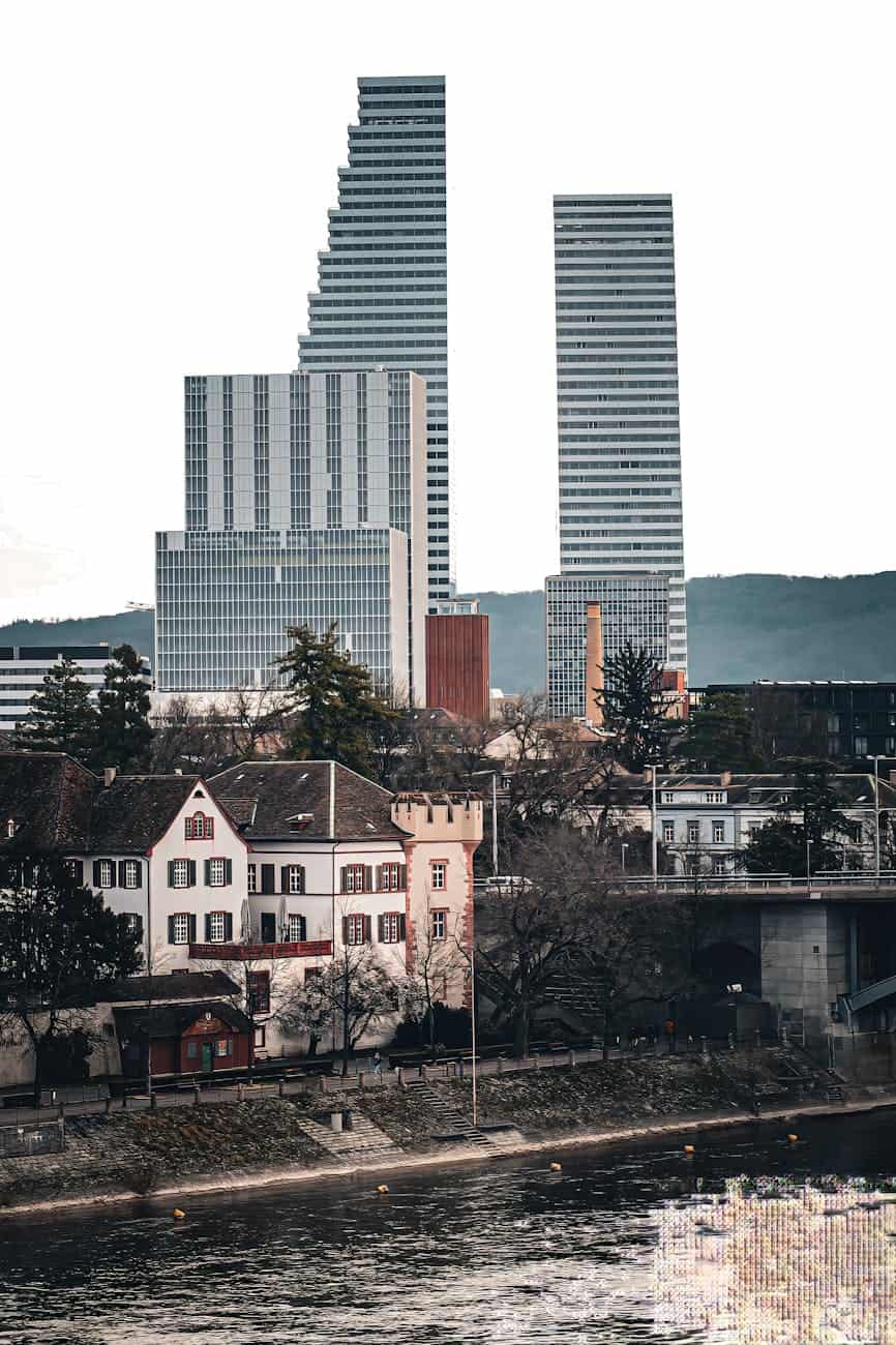 roche tower skyscraper behind river and buildings in basel in switzerland