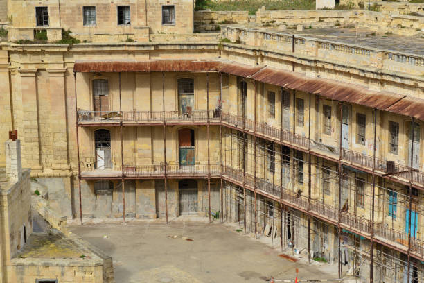 A historic stone building with multiple levels of balconies surrounds a quiet inner courtyard.