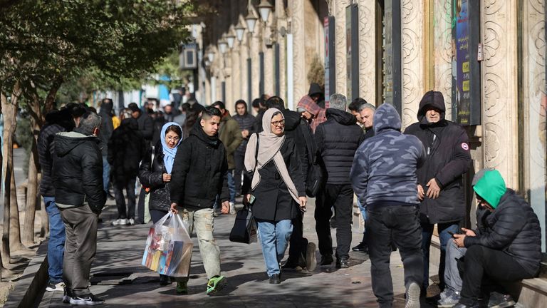 People walk past shops in Tehran. File pic