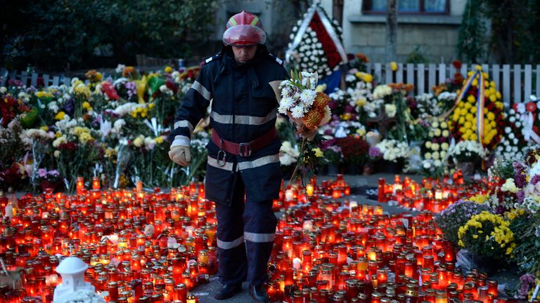 A fireman walks between candles as thousands for victims of the Bucharest nightclub fire. Pic: Reuters