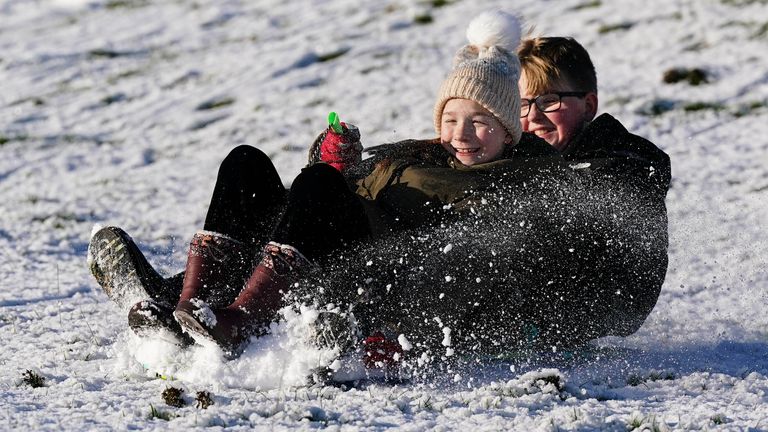 Children sledging down snowy hills at Burton Dassett Hills Country Park. Pic: PA