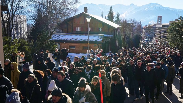 Hundreds of people walked in silence to the site of the tragedy in the Swiss ski resort of Crans-Montana. Pic: AP