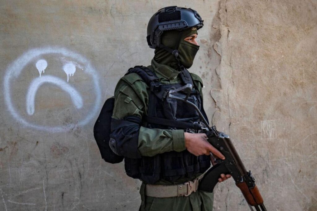 A member of the terrorist organization YPG-led SDF member walks past a house during a raid in Raqa, in Syria, January 29, 2023. (AFP Photo)