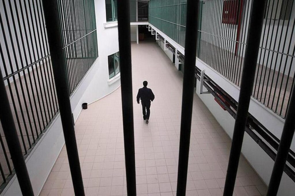 A prison officer is seen walking behind metal bars, date and time undisclosed. (AA Photo)