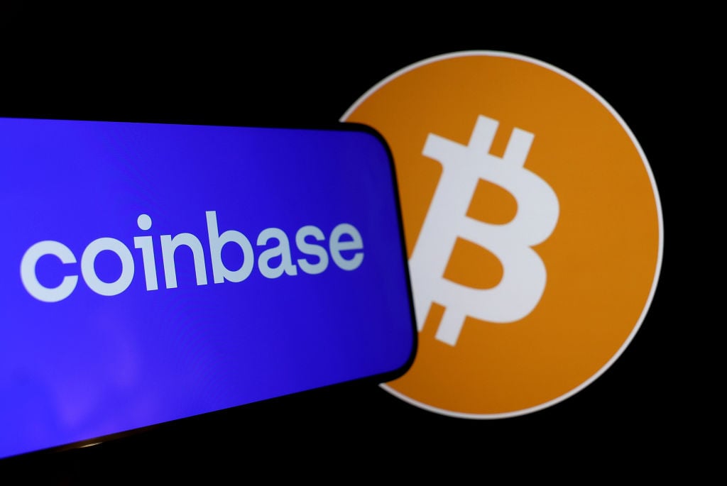 What Is One of the Best Crypto Stocks to Hold for the Next 10 Years? A phone displaying the Coinbase logo next to Bitcoin.