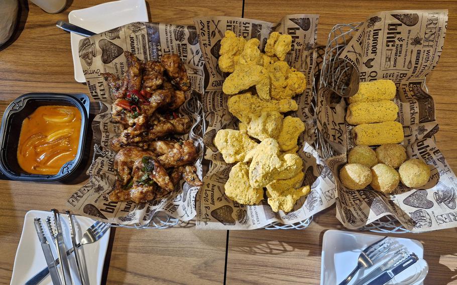 Korean foods on plates are lined up on a table.