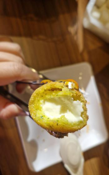 A cut-in-half cheese ball reveals the oozy cheese inside.