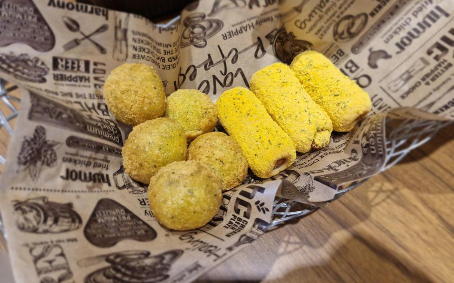 Cheese balls and yellow-dusted hot dogs sit on a paper lining.