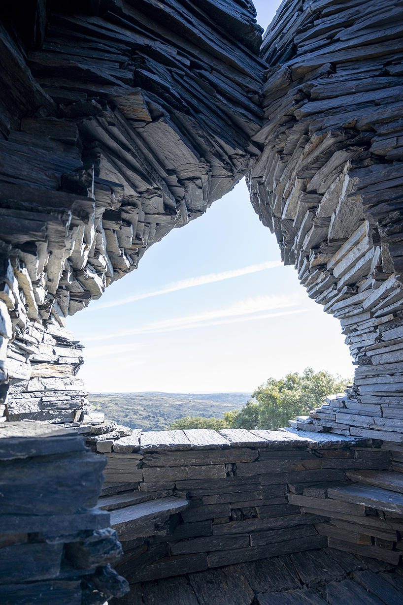 atelier yokyok sculpts sphere land installation out of black schist and granite in portugal