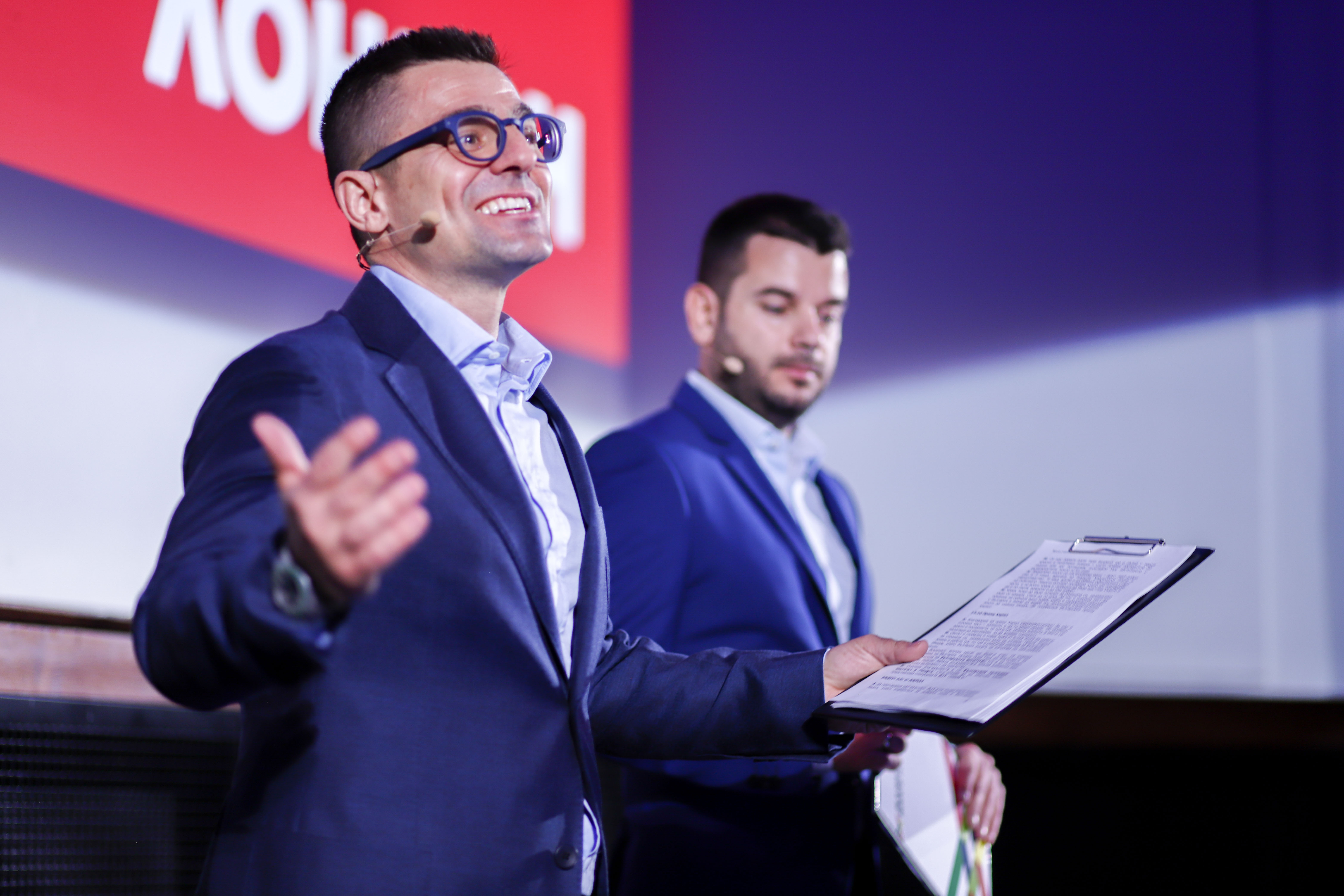 Andrey Arnaudov speaking with a microphone, and Ivan Hristov holding papers.