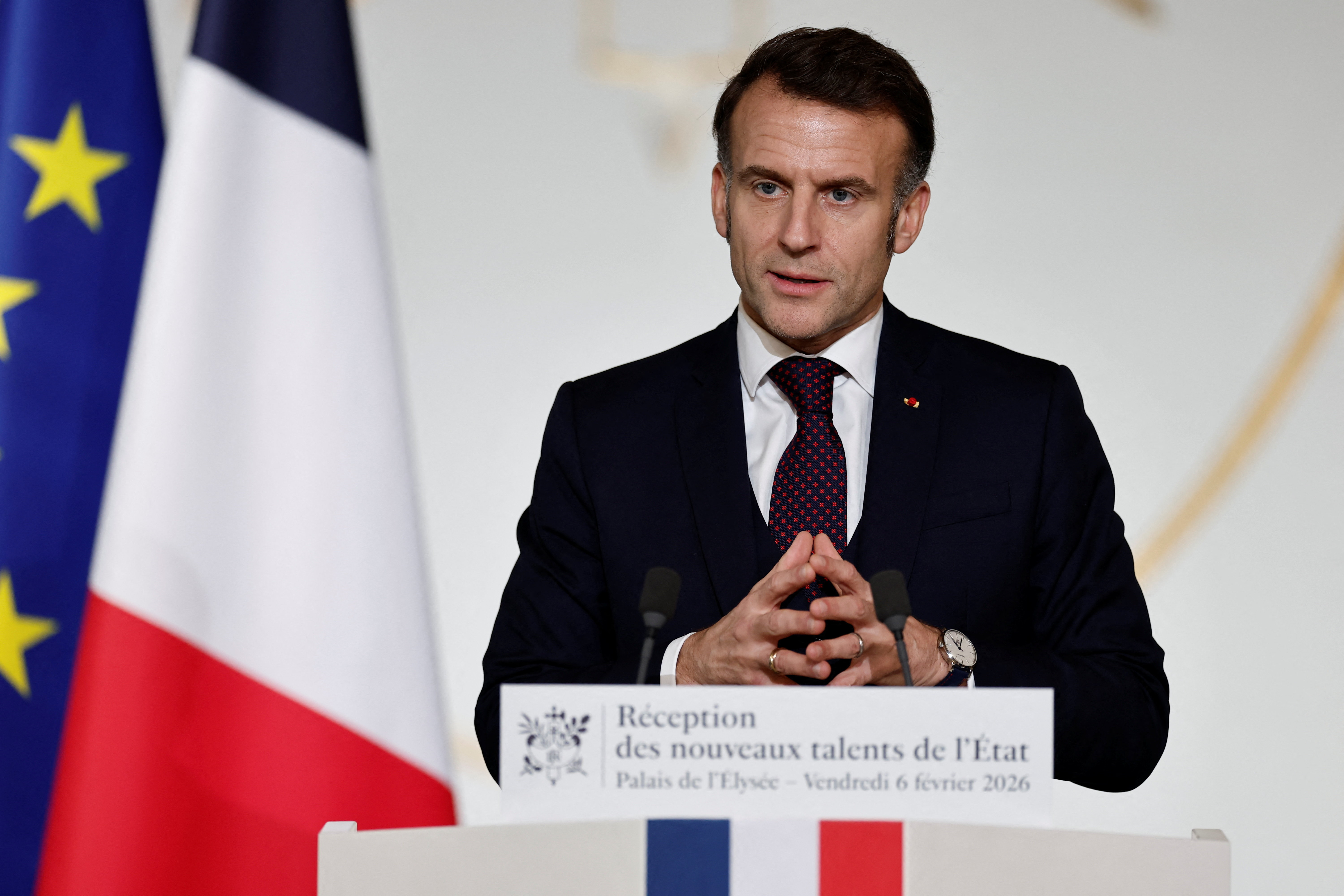French President Emmanuel Macron speaking at a podium with French and European Union flags behind him.