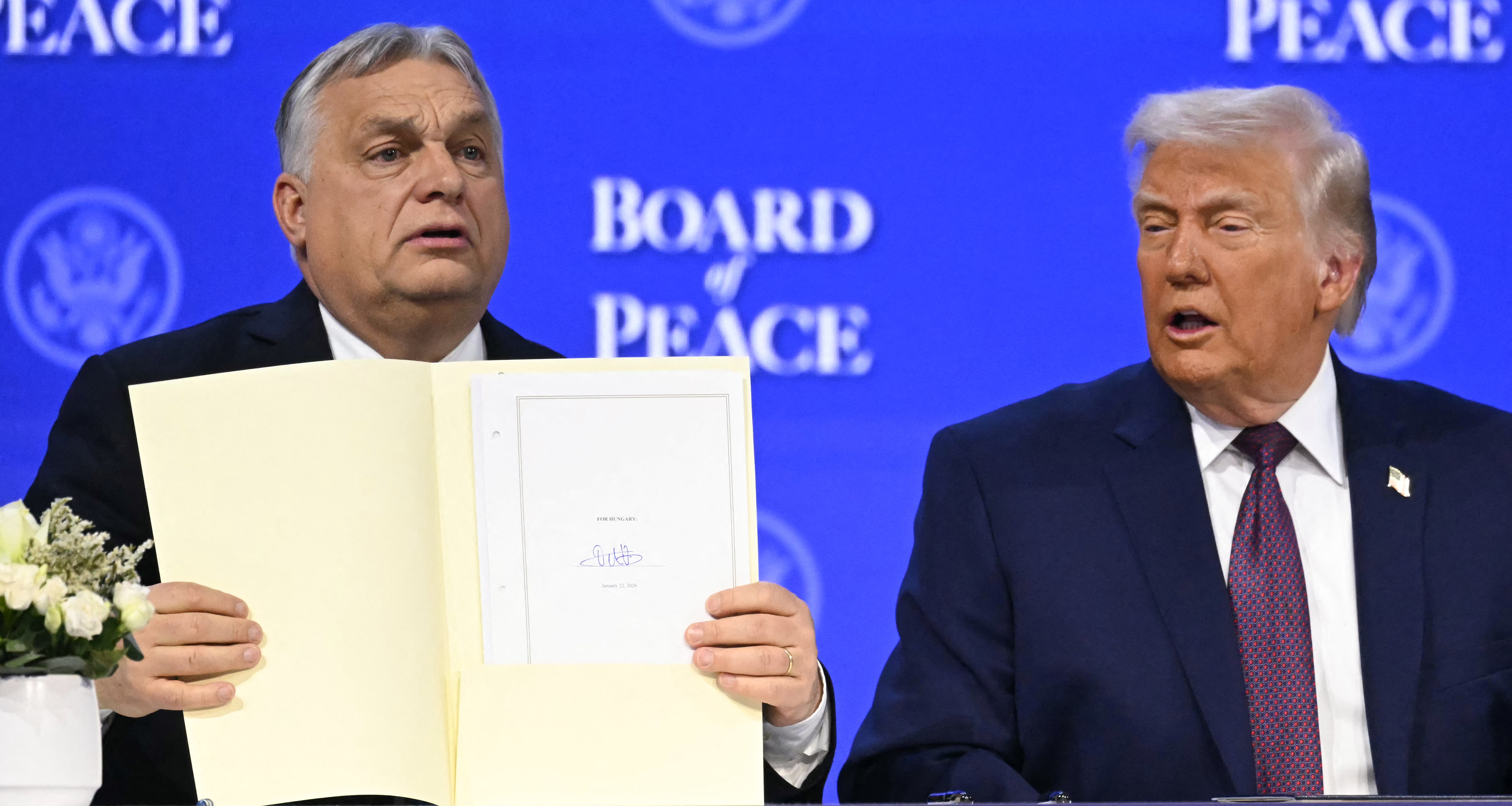 Hungary's Prime Minister Viktor Orban holds a founding charter next to US President Donald Trump at the "Board of Peace" meeting.