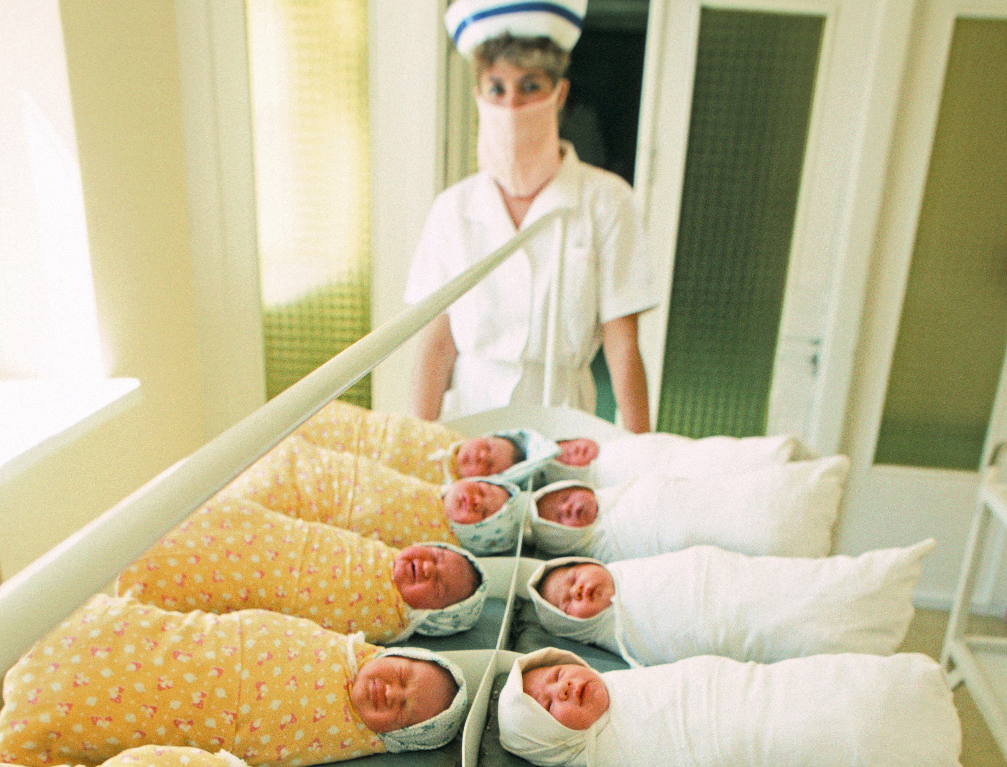 A nurse watches over swaddled newborns in a maternity hospital in Vilnius, Lithuania.