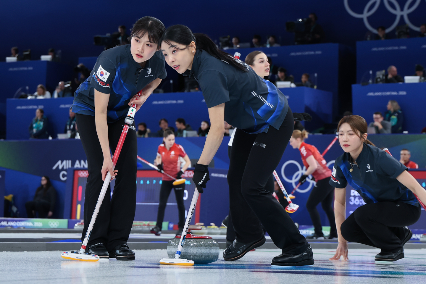 Seol Ye-eun, left, and Kim Min-ji of Korea sweep the ice during a round-robin match against Switzerland in the women's curling tournament at the Winter Olympics at the Cortina Curling Olympic Stadium in Cortina d'Ampezzo, Italy, on Feb. 17.  [YONHAP] 
