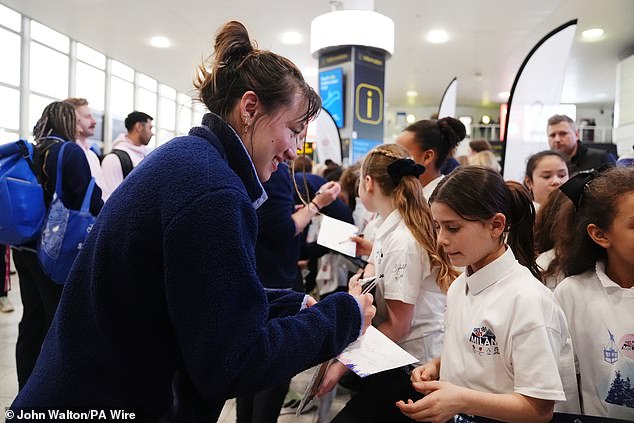 Atkin signs autographs for young fans who were part of the homecoming at Gatwick