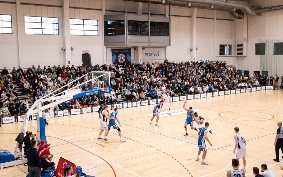 A view of a basketball game with fans in the stands.