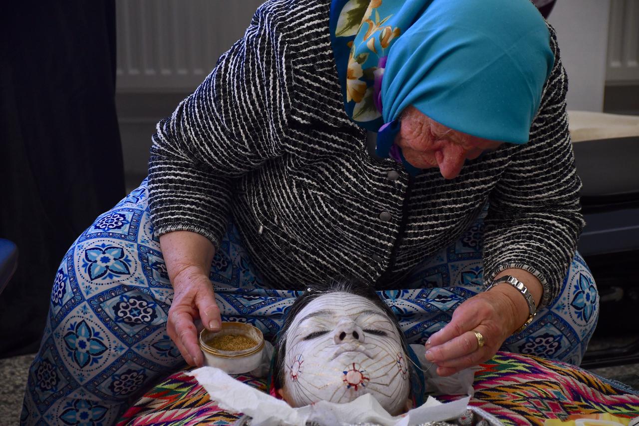A bride sits as her face is painted according to centuries-old wedding tradition. February 3, 2026. (AA Photo)