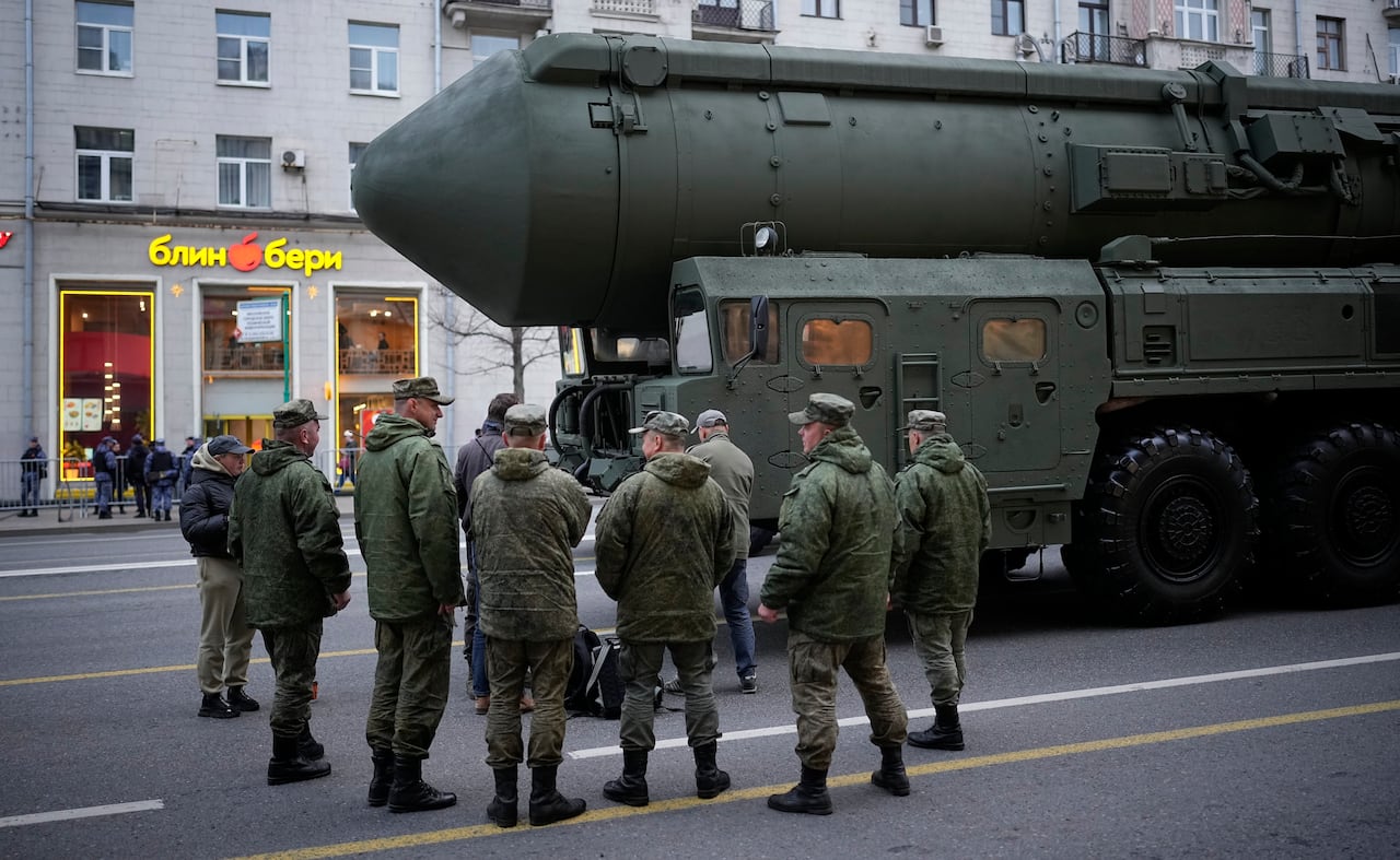 Soldiers stand next to a Russian RS-24 Yars ballistic missile parked along a street in Moscow.
