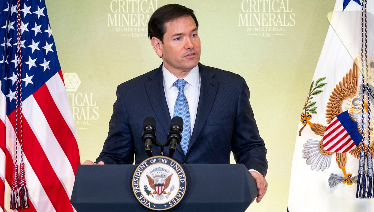 Marco Rubio stands at a podium, flanked by flags, in front of a backdrop with the words 'Critical Minerals Ministerial.'