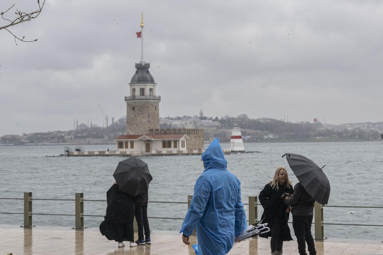 People walk along the seaside near the Maiden’s Tower during heavy rain that affected Uskudar Beach and the surrounding area in Istanbul, Türkiye, January 11, 2026. (AA Photo)