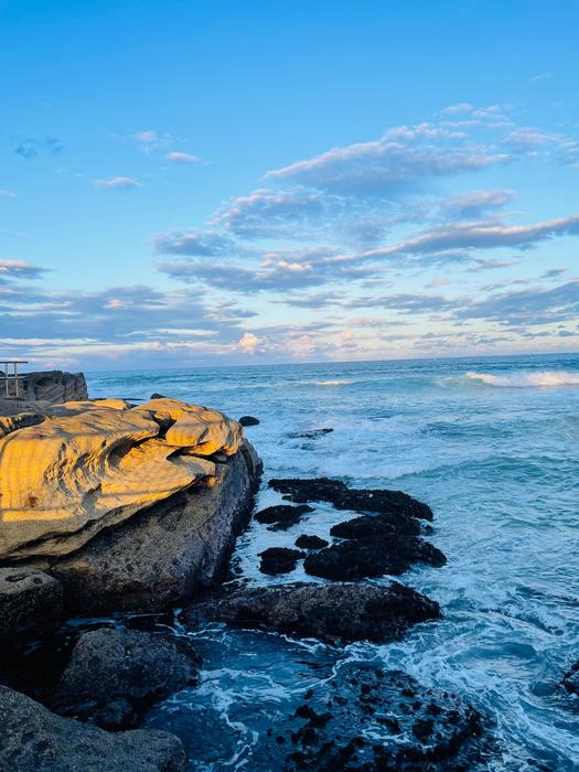 Waves crash against rock formations at Manly Beach, Australia