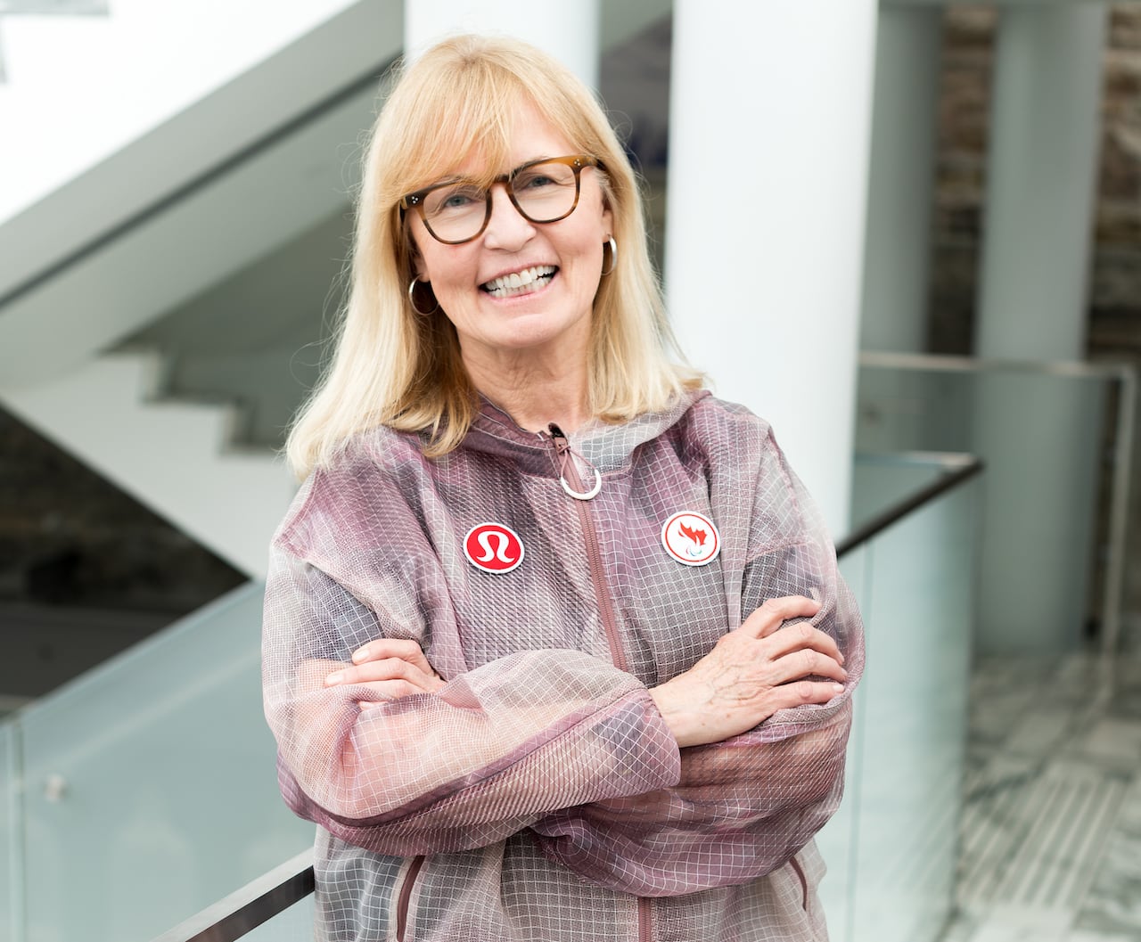 A woman stands with her arms folded.