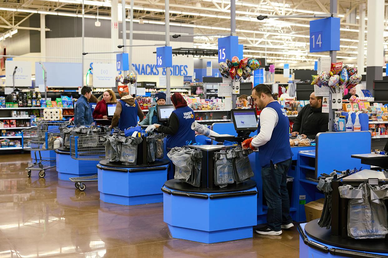 Cashiers and customers are lined up at a series of blue checkout aisles inside a Walmart.  (Brian Kaiser / Bloomberg via Getty Images file)