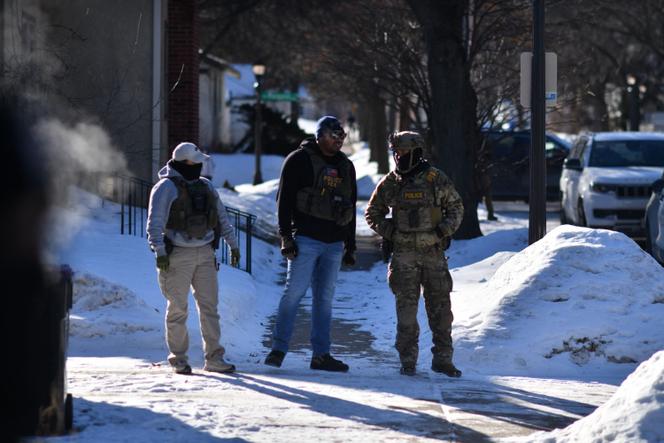 ICE agents block an intersection during an immigration enforcement operation in a St. Paul, Minnesota, neighborhood following a multi-vehicle accident on January 31, 2026. 