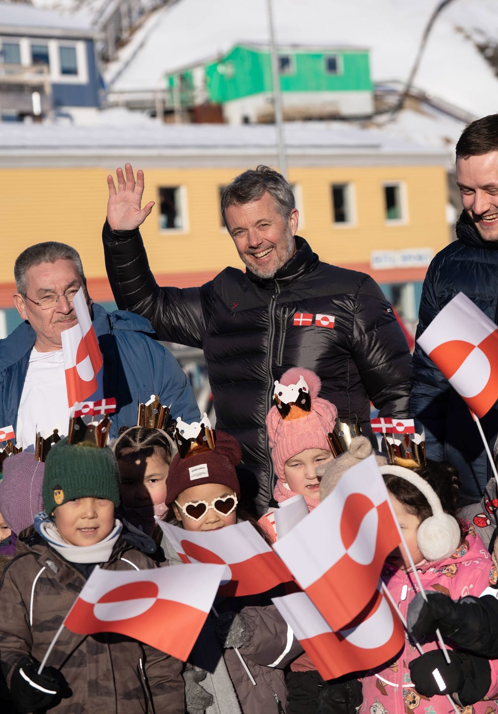 Group of children and adults celebrating with flags.