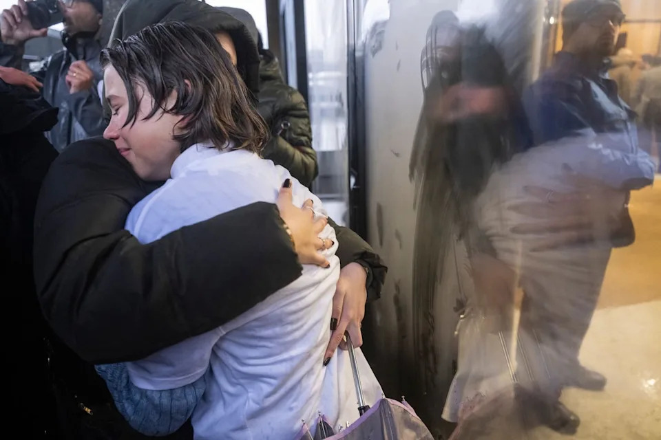 Family members of the victims hug ahead of the hearing (Keystone)