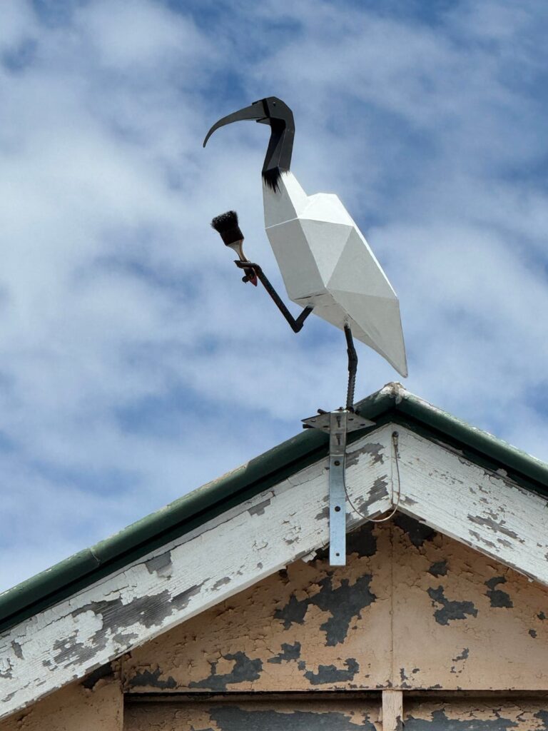 Name our Binnie from Brisbane artist Ryan, aka @sethius.art - Paintbrush in claw, our feathered helper sits atop the Morningside School of Arts community hall!