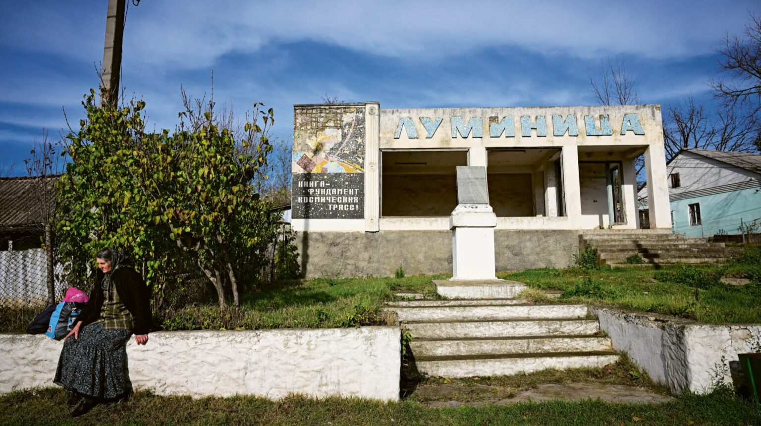On the Edge of Europe A woman rests beside the abandoned library ‘Luminita’ (The Glim), its name written in Cyrillic letters, in the village of Cimișeni, Moldova, 12 November 2023