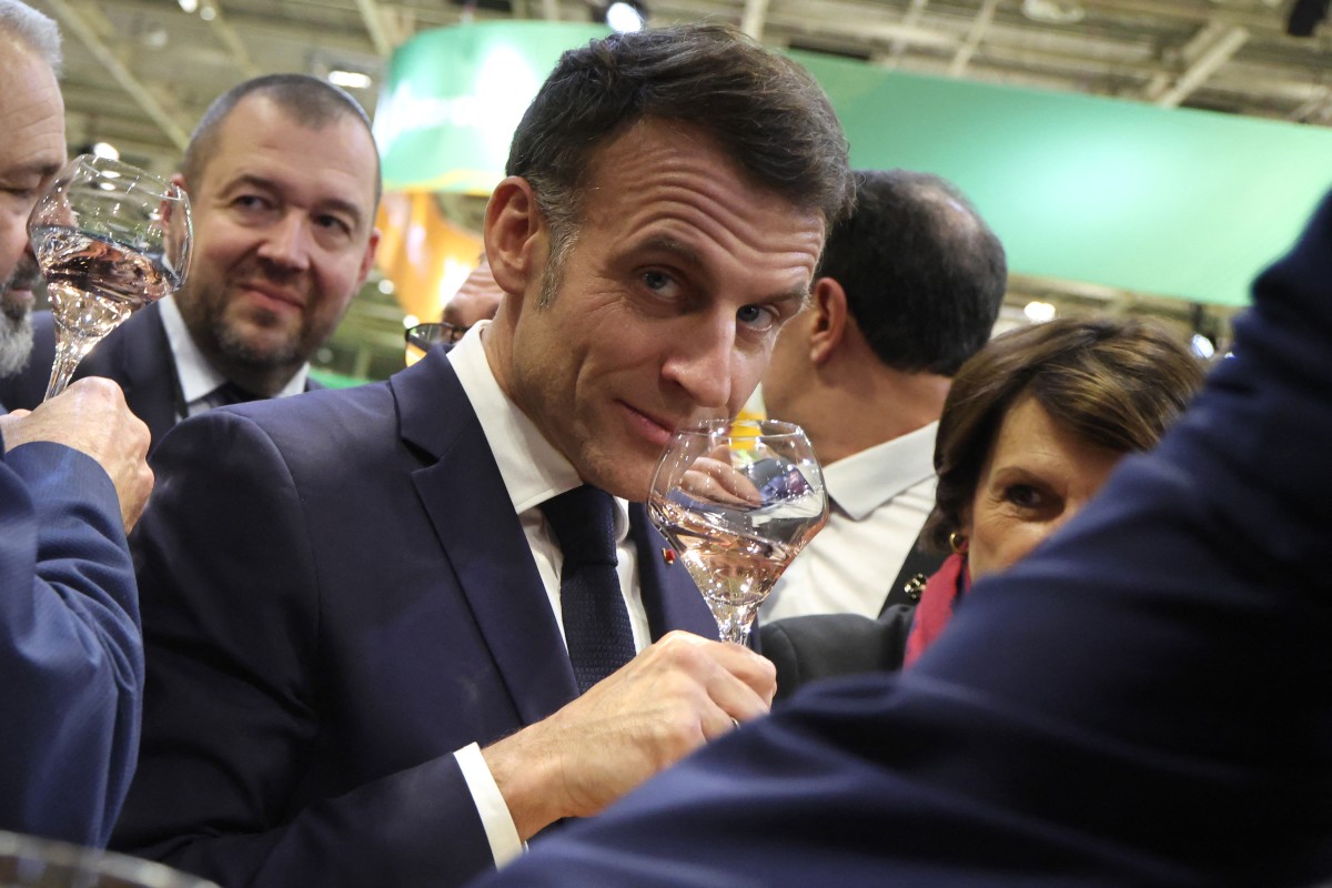 France's President Emmanuel Macron tastes wine, he is photographed sniffing the glass and cocking an eye at the photographer