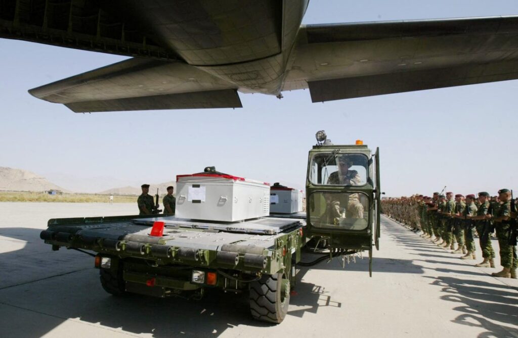 Eugene Lang: Canada Exceeded U.S. Expectations in the Afghanistan Mission Canadian flag-draped casket arrives at Kandahar Airfield as military personnel pay respects during Afghanistan mission repatriation ceremony. (Photo Credit: RICHARD VOGEL / POOL / AFP)