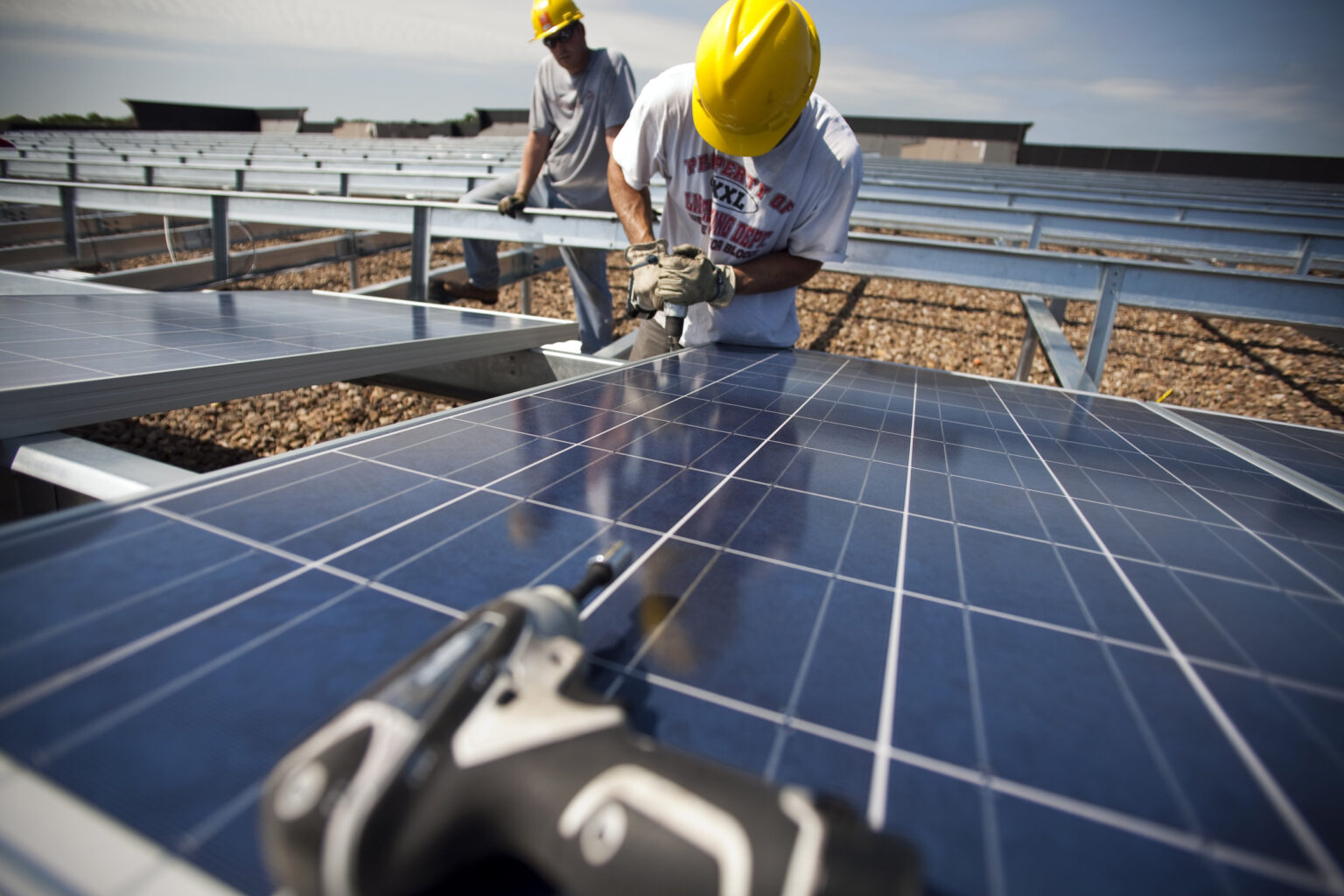 Contractors install solar panels on the roof of a department store in Hamilton Township, N.J. Credit: Robert Nickelsberg/Getty Images