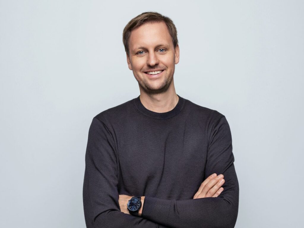 caucasian male in long sleeved dark tee arms folded