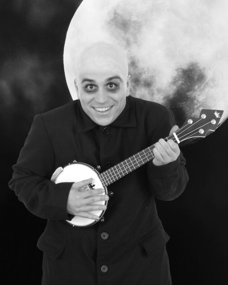 A black and white photo of the lovable Uncle Fester playing a banjo against the backdrop of a full moon. (Courtesy photo)