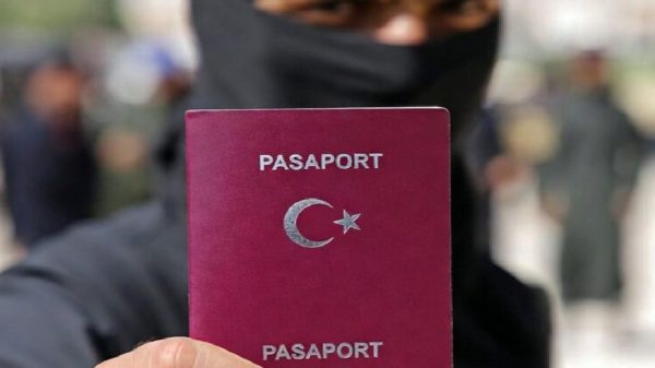 Masked man holding Turkish passport