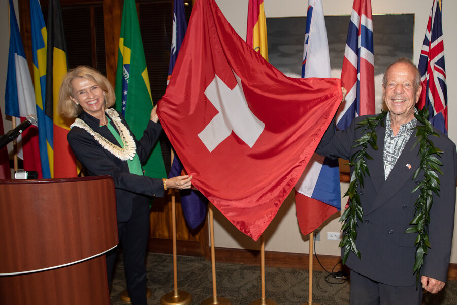 A woman and a man holding a Swiss flag
