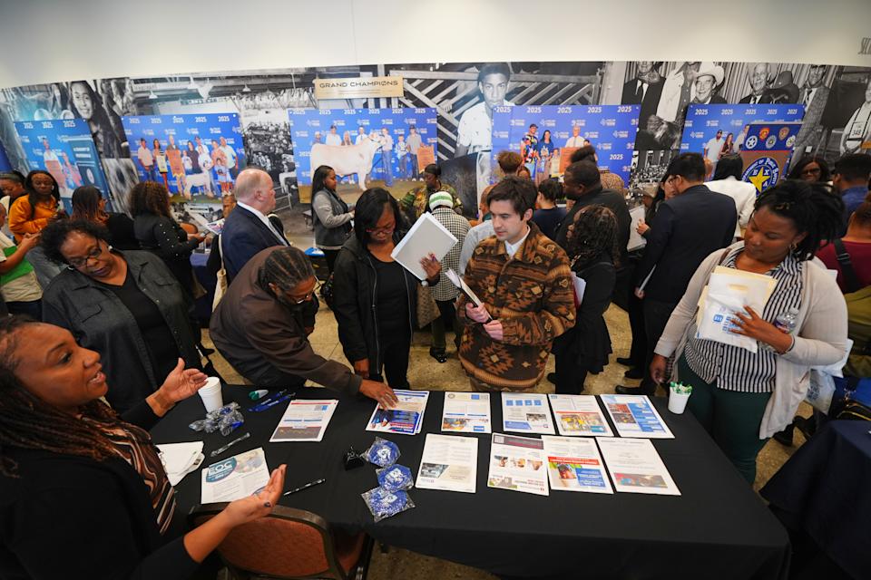 Job seekers listen for information on employment during a hiring fair at Fair Park in Dallas, Wednesday, Jan. 14, 2026. (AP Photo/LM Otero)