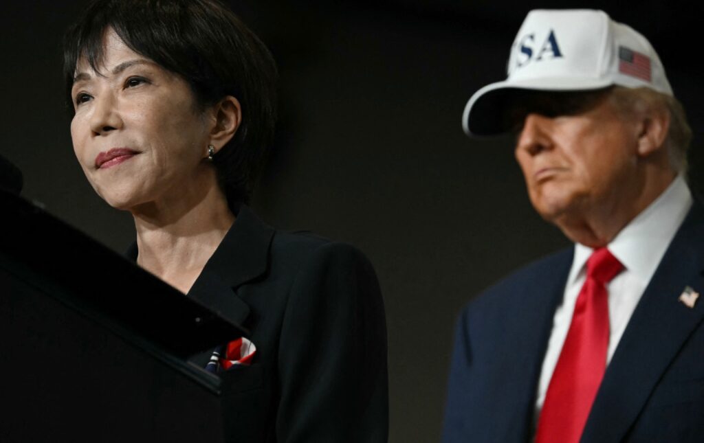 Donald Trump looks over Japanese Prime Minister Sanae Takaichi as she speaks to US Navy personnel aboard the USS George Washington aircraft carrier at Yokosuka naval base on October 28, 2025.