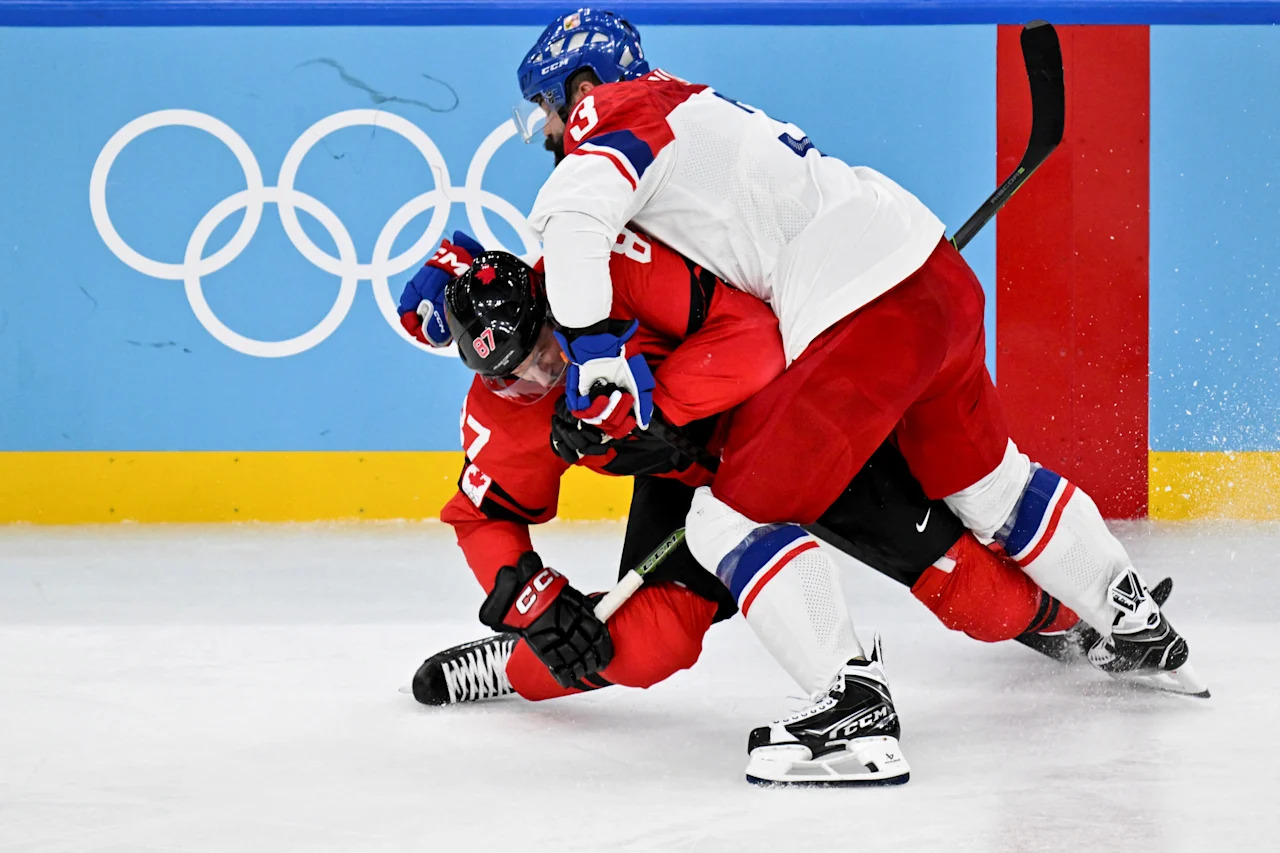 Czech Republic's #03 Radko Gudas (R) tackles Canada's #87 Sidney Crosby during the men's play-off quarter-final ice hockey match between Canada and Czech Republic at the Milano Santagiulia Ice Hockey Arena during the Milano Cortina 2026 Winter Olympic Games in Milan, on February 18, 2026.