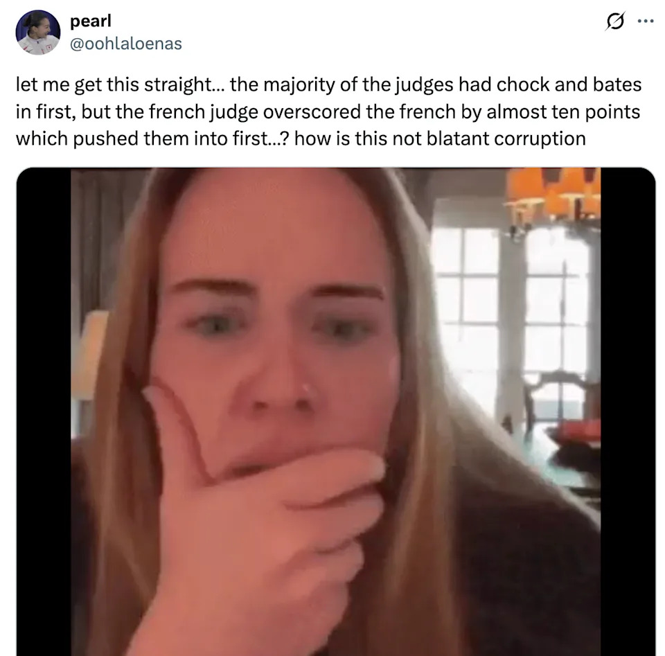 A person looks puzzled while appearing on a video call. There is a tweet overlay discussing a perceived scoring controversy in a competition