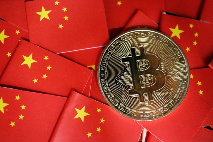 A representation of Bitcoin is seen amid China's flags in this photo illustration created in September 2021. Reuters-Yonhap