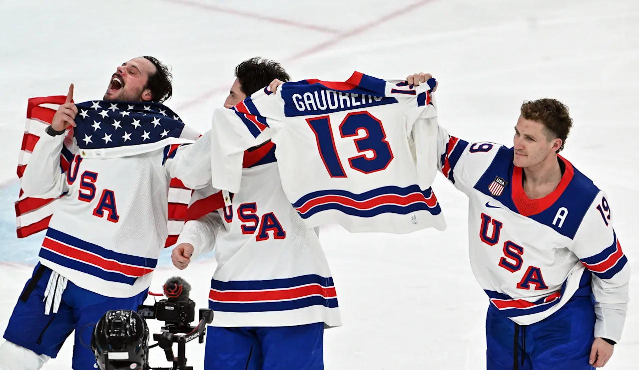 22 February 2026, Italy, Mailand: Olympia, Olympic Winter Games Milan Cortina 2026, ice hockey, men, Canada - USA, final round, final, USA players cheer for victory with a jersey of the late Johnny Gaudreau. Photo: Peter Kneffel/dpa (Photo by Peter Kneffel/picture alliance via Getty Images)