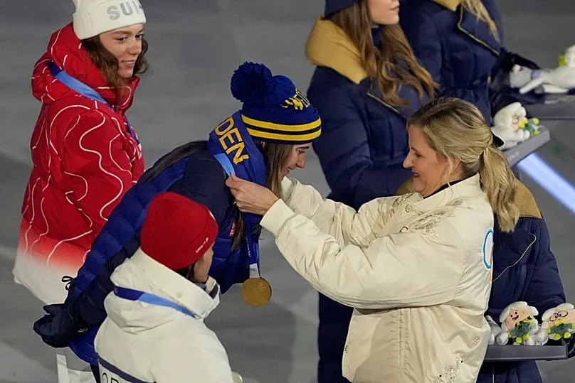 IOC President Kirsty Coventry awards Ebba Andersson, of Sweden, the gold medal at medal ceremony for the cross country skiing women's 50km mass start classic, Feb. 22, 2026.