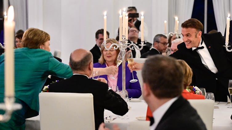 A man and a woman chink champagne flutes.